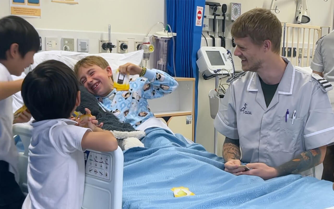 A male nurse smiling with a group of children, pr agency brentwood; pr agency braintree; pr agency basildon; pr agency colchester; pr agency chelmsford; pr agency cambridge; pr agency epping; pr agency essex; pr agency harlow; pr agency herts; pr agency ipswich; pr agency suffolk; pr southend; pr thurrock; pr norfolk; commercial photographer colchester; commercial photographer essex; charity pr; event pr; tourism pr