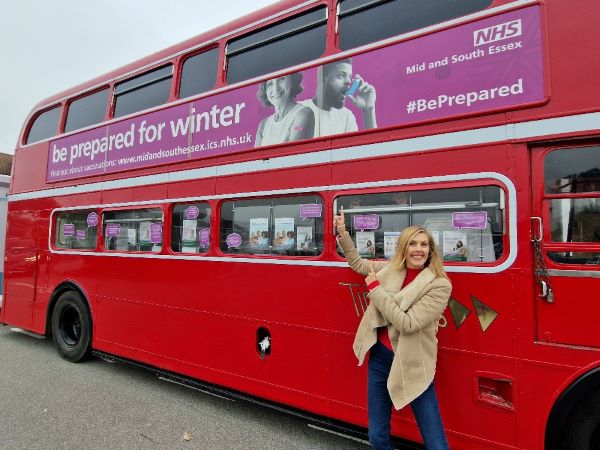 Hilary Collins, MD, Big Wave PR pictured with double decker bus for NHS vaccination campaign