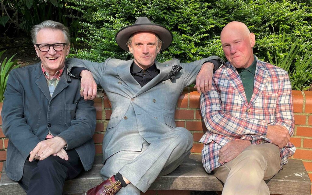 three men sitting on a seat